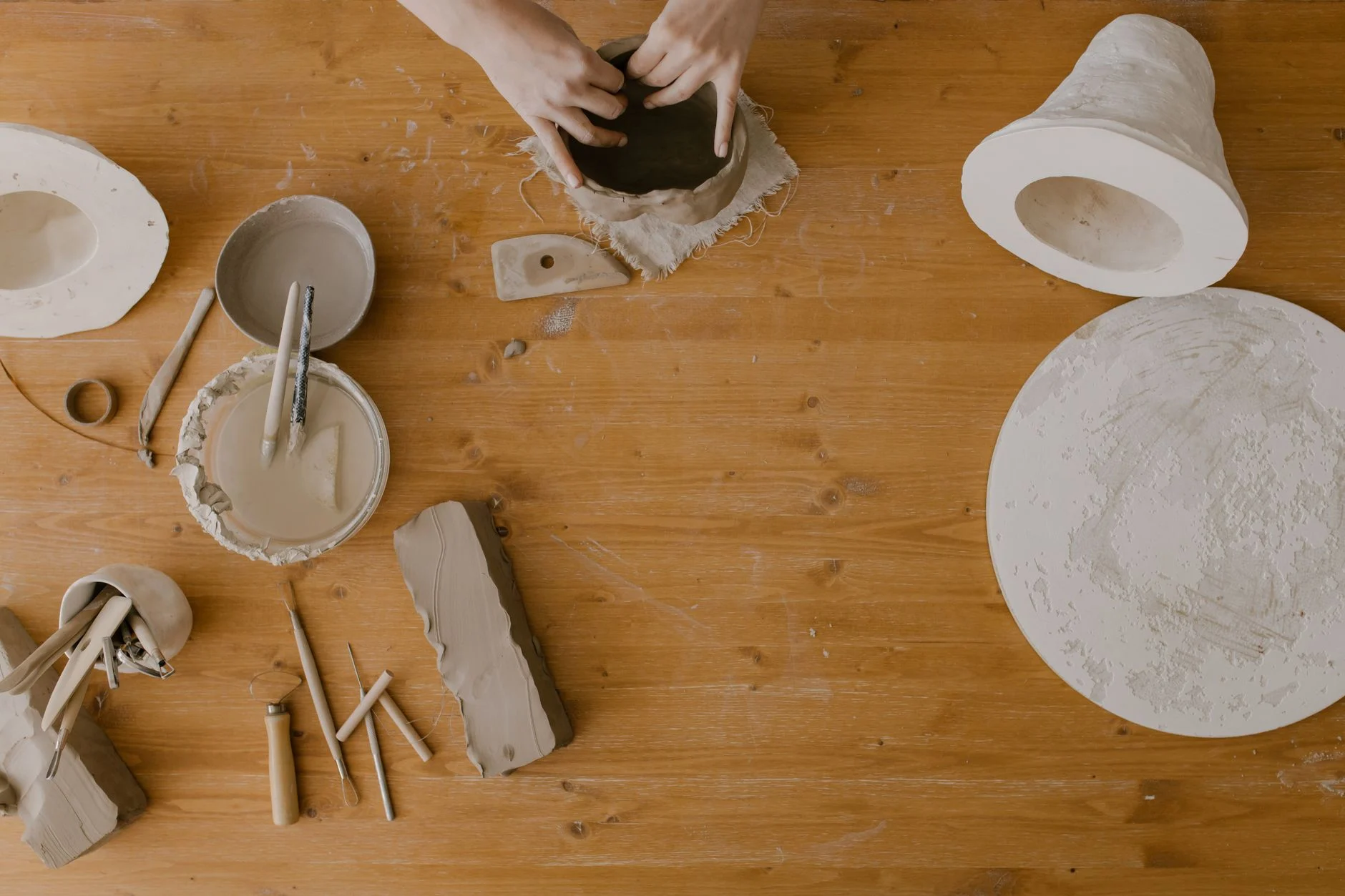 Hands shaping clay on a pottery wheel during a couples date night