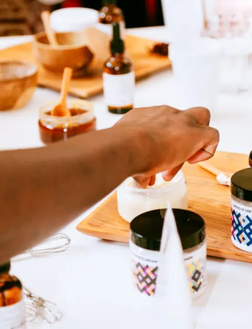 Hands crafting botanical skincare in a workshop
