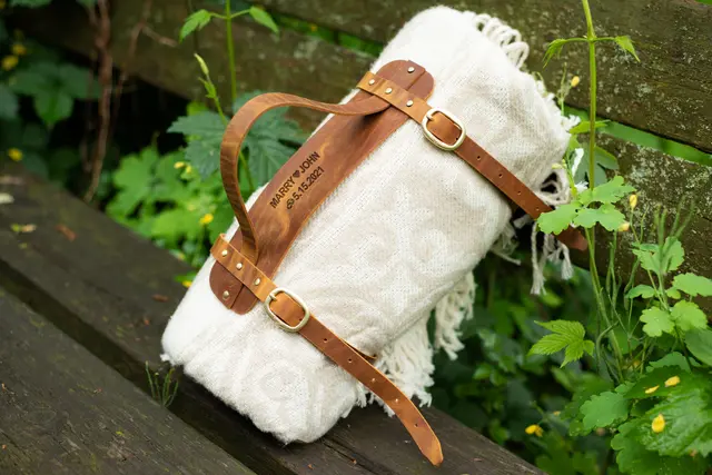 Rolled leather picnic blanket harness for spontaneous park dates