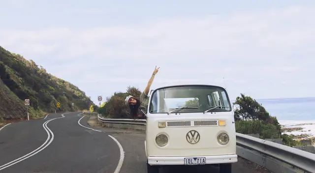 Vintage cream Kombi van on a winding Australian coastal road